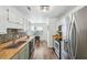 Kitchen with stainless steel appliances, light green cabinets and wooden countertops at 1027 Wayfarer Ln, Charleston, SC 29412