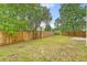Backyard features a wooden fence for privacy, a well-kept lawn, and mature trees in the background at 1042 Cobblestone Blvd, Summerville, SC 29486