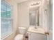 Well-lit half bathroom with a window, toilet, and vanity with a mirror above the sink at 1042 Cobblestone Blvd, Summerville, SC 29486