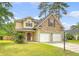 Inviting two-story home featuring a two-car garage, manicured lawn, and mature trees under a partly cloudy sky at 1042 Cobblestone Blvd, Summerville, SC 29486