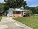 View of home with concrete driveway, manicured lawn, tidy landscaping, and brick foundation at 105 Pandora Dr, Goose Creek, SC 29445