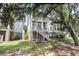 Charming backyard featuring a two-story porch and lush green lawn and shade trees at 1093 Ave Of Oaks, Charleston, SC 29407