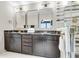 Bathroom with double sinks, black marble countertop, gold hardware, and a glass shower with tile at 1093 Ave Of Oaks, Charleston, SC 29407