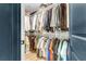 A walk-in closet with rods and shelving, filled with a wide array of clothes and accessories at 1093 Ave Of Oaks, Charleston, SC 29407