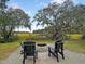 Backyard with comfortable chairs around a brick fire pit, perfect for outdoor entertaining at 1093 Ave Of Oaks, Charleston, SC 29407