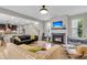 Bright living room featuring a fireplace, hardwood floors, and open access to the modern kitchen at 1093 Ave Of Oaks, Charleston, SC 29407
