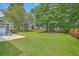 Landscaped backyard featuring a well-maintained lawn and a wooden fence, with mature trees and a patio at 111 Kapalua Run, Summerville, SC 29483