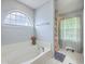 Bright primary bathroom with a large bathtub with blue walls, and tile flooring, with a large window at 111 Kapalua Run, Summerville, SC 29483