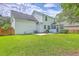 Backyard featuring a well-maintained lawn, wooden fence, mature trees and a covered patio with a grill at 111 Kapalua Run, Summerville, SC 29483
