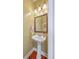 Half bathroom featuring a pedestal sink, decorative mirror, and a classic lighting fixture at 111 Kapalua Run, Summerville, SC 29483