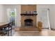 Living area featuring a brick fireplace with wooden mantle, adjacent to a window and a door to the outside at 116 Runnymede Ln, Summerville, SC 29485