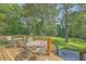 Large wooden back deck with metal patio furniture, wooden railings, and a wooded backyard view at 121 Woodland Dr, Summerville, SC 29485