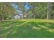 Spacious backyard featuring a fire pit, lush green grass, and mature trees at 121 Woodland Dr, Summerville, SC 29485