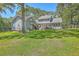 Large backyard view featuring a deck, a hot tub, lush green grass, and mature trees at 121 Woodland Dr, Summerville, SC 29485