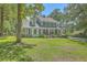 Charming two-story home with a red door, dormer windows, and mature landscaping at 121 Woodland Dr, Summerville, SC 29485
