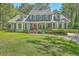 Inviting two-story home featuring a covered porch, neat lawn, and traditional architectural details at 121 Woodland Dr, Summerville, SC 29485