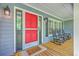 Charming porch with a bright red front door and inviting rocking chairs and views at 121 Woodland Dr, Summerville, SC 29485