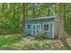 Backyard shed with a wooden ramp surrounded by lush greenery and mature trees at 121 Woodland Dr, Summerville, SC 29485