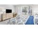 Comfortable bedroom featuring a large window, dresser, TV and warm inviting tones at 1355 Dunlin Ct # Share D, Kiawah Island, SC 29455