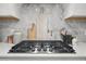 Stylish cooktop with marble backsplash, stainless steel appliances, and white cabinets at 1387 Thin Pine Dr, Johns Island, SC 29455