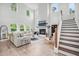 Bright living room boasts a fireplace, large windows, hardwood floors, and a staircase at 1387 Thin Pine Dr, Johns Island, SC 29455