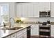 Modern kitchen with white cabinets, granite countertops, and stainless steel appliances at 1446 Crane Creek Dr, Mount Pleasant, SC 29466