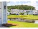 Scenic view of a tranquil pond surrounded by well-maintained lawns and neighboring homes at 1446 Crane Creek Dr, Mount Pleasant, SC 29466