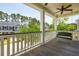 Inviting covered porch with a swing, ceiling fan, and serene views of the neighborhood at 1446 Crane Creek Dr, Mount Pleasant, SC 29466