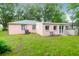Spacious backyard featuring a pink exterior, lush grass, and shaded areas at 1514 Patterson Ave, Charleston, SC 29412