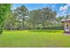 Expansive backyard with lush green lawn, mature trees, and access to a creek at 17 Johnson Rd, Charleston, SC 29407