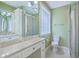 Bright bathroom featuring dual sinks, glass-enclosed shower, and a glass block window at 17 Johnson Rd, Charleston, SC 29407