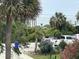 Scenic view of the beach and ocean through lush tropical foliage and parked cars at 1736 E Ashley Ave, Folly Beach, SC 29439