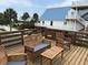 Relax on this wooden deck with outdoor seating, perfect for enjoying sunny days and serene views at 1736 E Ashley Ave, Folly Beach, SC 29439