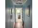 Hallway with blue wood paneling leading to a brightly lit room with wooden floors at 1736 E Ashley Ave, Folly Beach, SC 29439