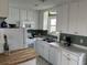 Bright kitchen with white cabinetry, appliances, butcher block counter, and adjacent dining space at 1736 E Ashley Ave, Folly Beach, SC 29439