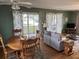 Inviting living and dining area features hardwood floors, neutral sofa, and screened porch access at 1736 E Ashley Ave, Folly Beach, SC 29439