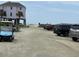 Vehicles and a golf cart are parked on a sandy lot near a beach access point at 1736 E Ashley Ave, Folly Beach, SC 29439
