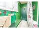 A small, outdated bathroom with green walls, a vintage tub, and swan-themed decor at 200 Fishburne St, Charleston, SC 29403