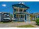 Charming two-story blue home featuring double balconies and a well-manicured front lawn at 200 Fishburne St, Charleston, SC 29403