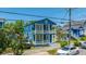 Charming two-story blue home with double balconies complemented by colorful neighboring houses at 200 Fishburne St, Charleston, SC 29403