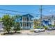 Picturesque two-story blue home with double balconies, complemented by colorful neighboring houses at 200 Fishburne St, Charleston, SC 29403