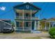 Charming two-story blue home featuring double balconies and a well-manicured front lawn at 200 Fishburne St, Charleston, SC 29403