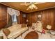 Comfortable living room featuring wood walls, vintage furniture, and a classic ceiling fan creating a cozy retreat at 200 Fishburne St, Charleston, SC 29403