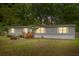 A single-story home with light gray siding, a small front porch, and green trees in the background at 201 Frank St, Summerville, SC 29483