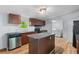 Well-lit kitchen area, stainless steel appliances, kitchen island and view of connecting utility area at 201 Frank St, Summerville, SC 29483