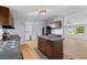 Bright kitchen with an island, stainless steel appliances, wood cabinets and laminate floors, offering functionality and style at 201 Frank St, Summerville, SC 29483