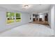 Spacious living room with carpet and views of the yard, seamlessly flowing into the kitchen area at 201 Frank St, Summerville, SC 29483