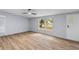 Bright living room featuring laminate floors, a ceiling fan and a large window overlooking the front yard at 201 Frank St, Summerville, SC 29483