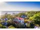 Stunning aerial view of a white multi-story home with a red roof near the coast and green trees at 202 Bank St, Mount Pleasant, SC 29464