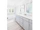 Bright bathroom with double vanity, modern mirrors, and a striped rug on the tile floor at 202 Bank St, Mount Pleasant, SC 29464